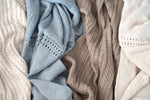 Wildflower Pop Knit Blankets Shown are the Cream Cable Knit, Cornflower Blue Lace Knit, Tan Cable Knit, and Cream Lace Knit