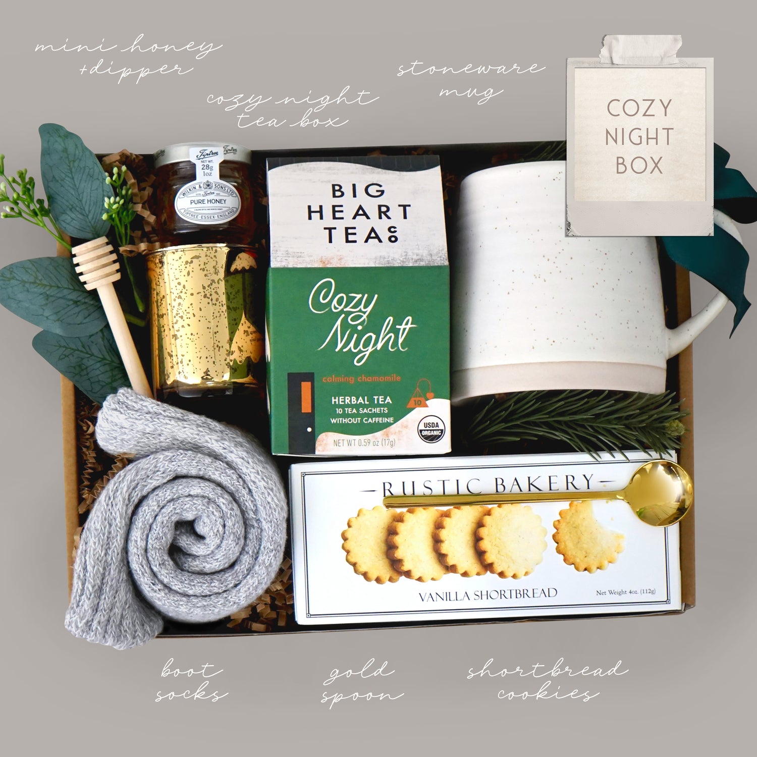 Cozy night gift box with tea, cookies, and other items on a gray background