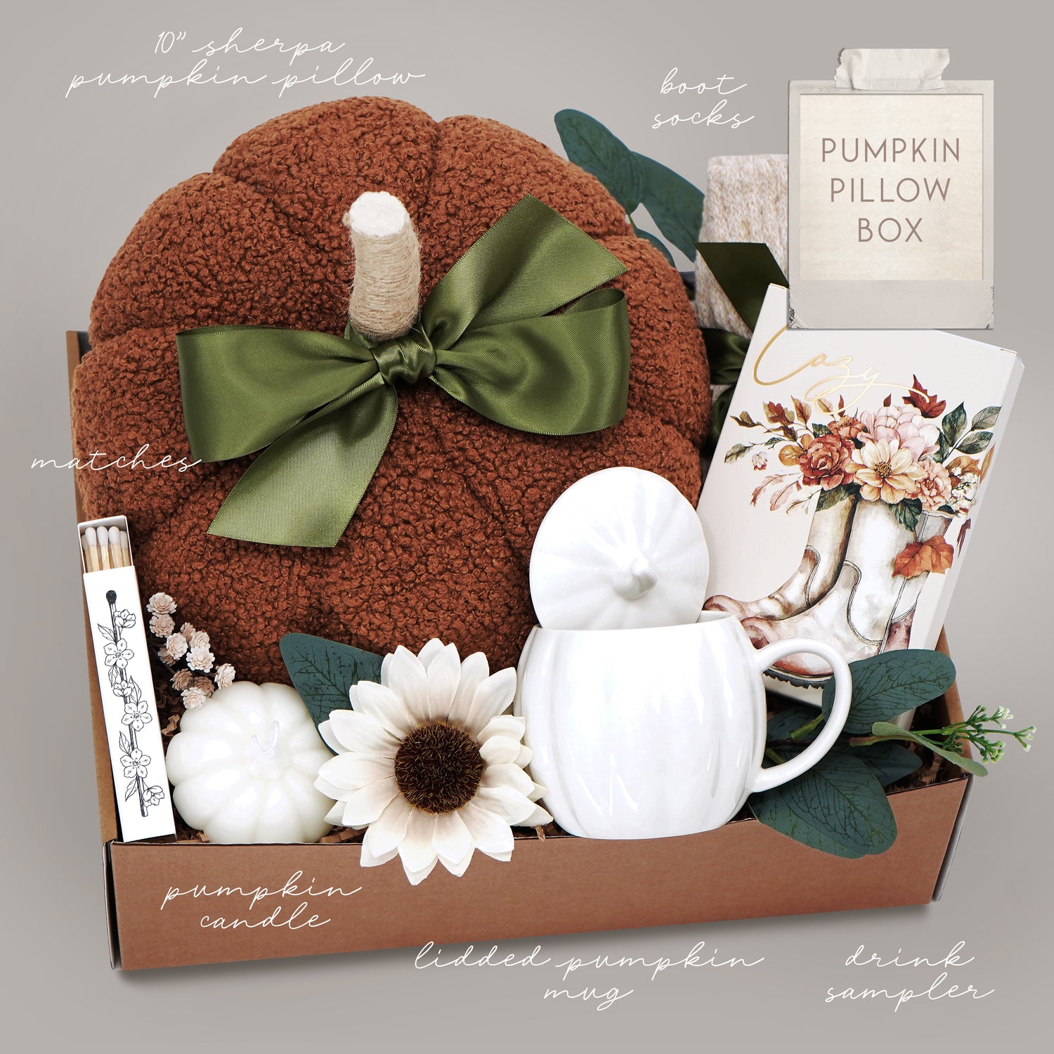 Gift basket with a plush pumpkin, pumpkin mug with lid, and decorative items on a gray background