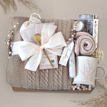 Wildflower Pop Cozy Cable Blanket Gift Box with tan cable knit blanket, Moonstruck Milk Chocolate, Floral bath salts, Lavender Sprig Mug, Cozy Boot socks, Tea, votive and Tea Light