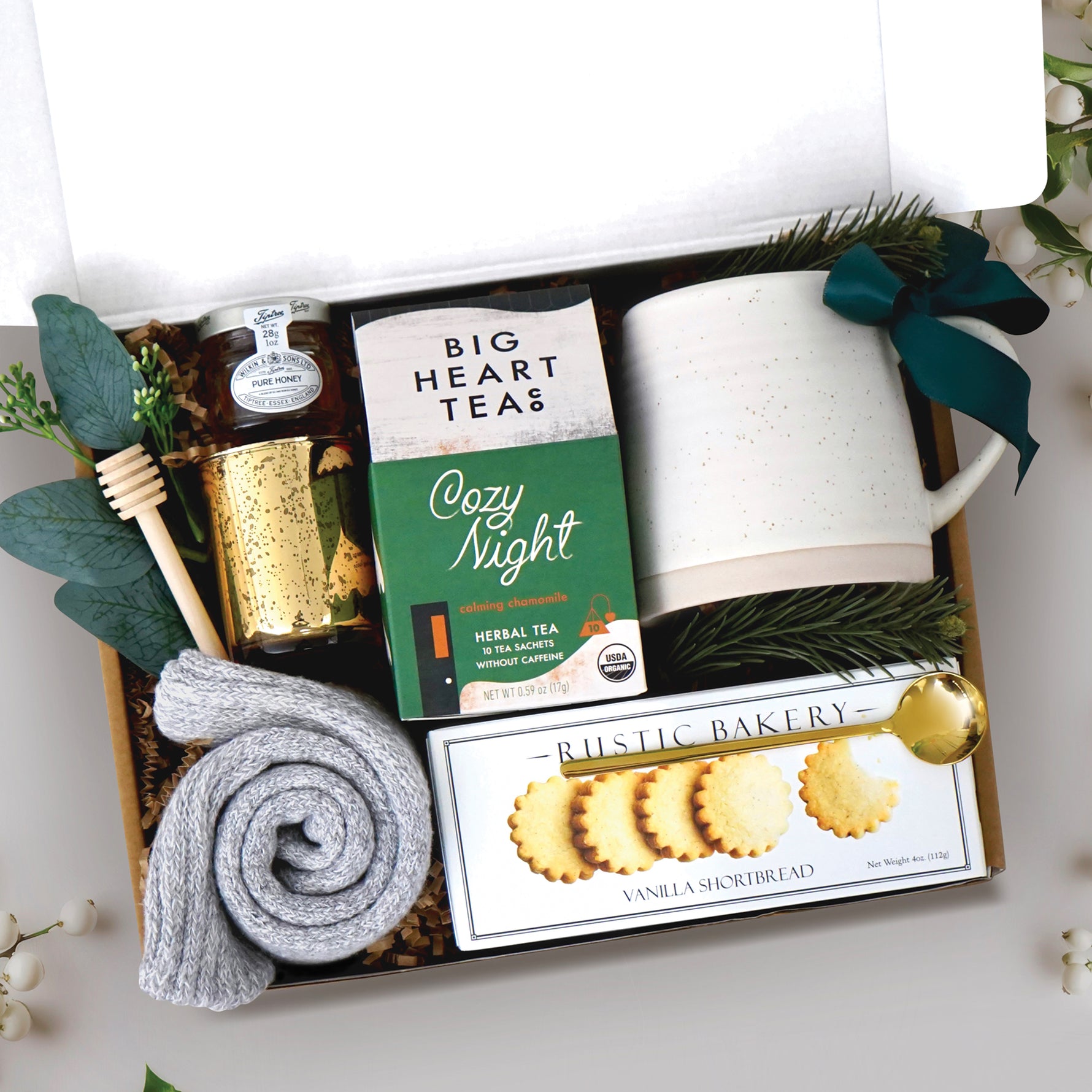 Cozy Night Gift Box comes with beehive ceramic mug, rustic bakery vanilla shortbread cookies, cozy night 10 count tea bags, mini honey and dipper, votive and tea light, and cozy socks
