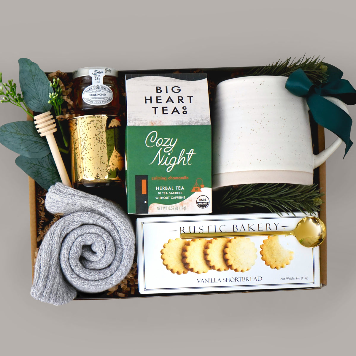 Gift basket with tea, cookies, and other items on a gray background