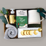 Gift basket with tea, cookies, and other items on a gray background