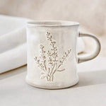 Ceramic mug with a rustic lavender design on a neutral background