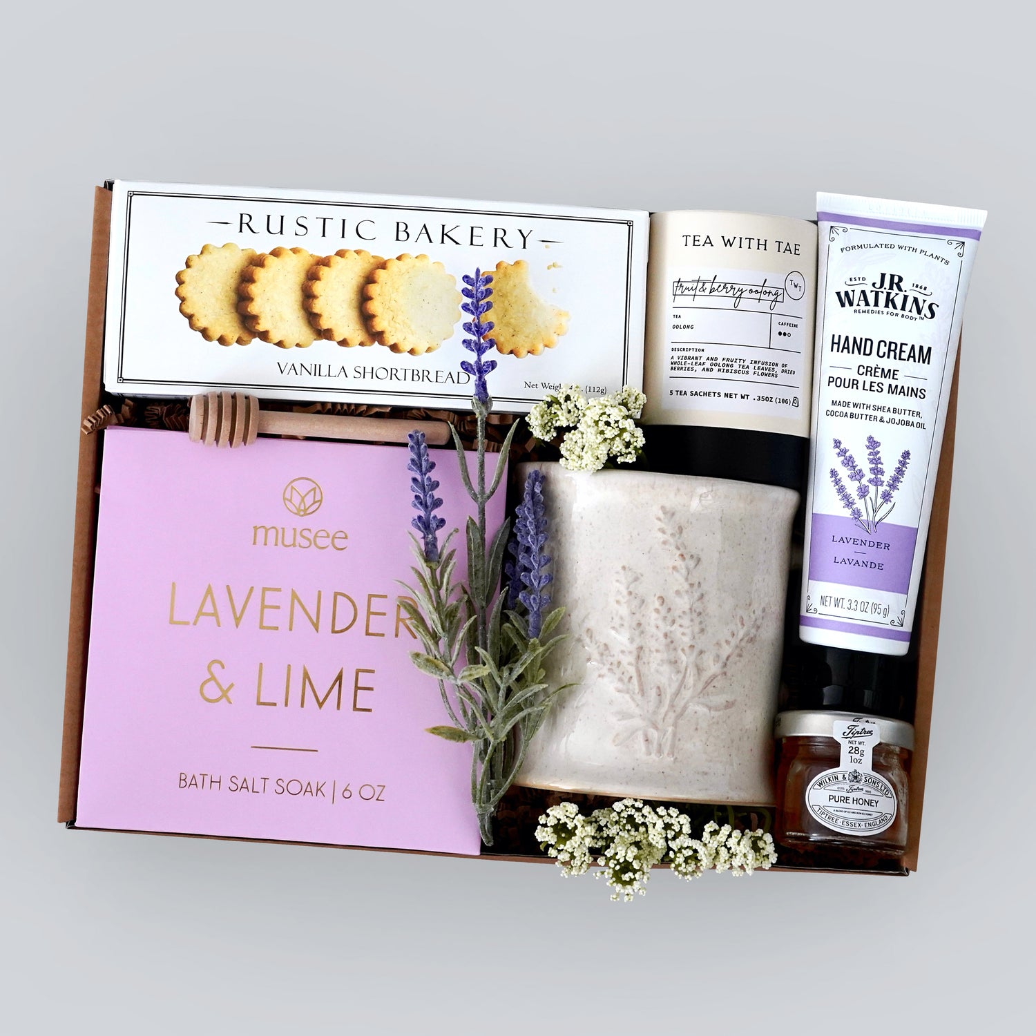 Wildflower Pop Gift box with lavender-themed products including a lavender mug, shortbread cookies, hand cream, tea, and mini honey on a gray background