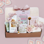 Wildflower Pop wildflower meadow blanket gift box with a cream lace knit blanket, Rosewater face mask, gold spoon, tea sampler, cream knit socks, faux rose, wildflower ceramic mug, wood butterfly ornament, Rustic bakery vanilla shortbread, Flower Market gardenia hand lotion