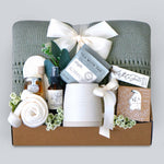 Gift box with tea, soap, and other items on a gray background