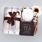 Scarf gift set with a pumpkin mug, tea sampler, and mini honey and dipper on a gray background
