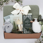 Wildflower Pop Silver Forest Blanket gift box, with sage green lace knit blanket, cream ribbed ceramic mug, grey cozy boot socks, silver votive and tea light, mini honey and dipper, silver birch and cedar shower steamers, and tea sampler