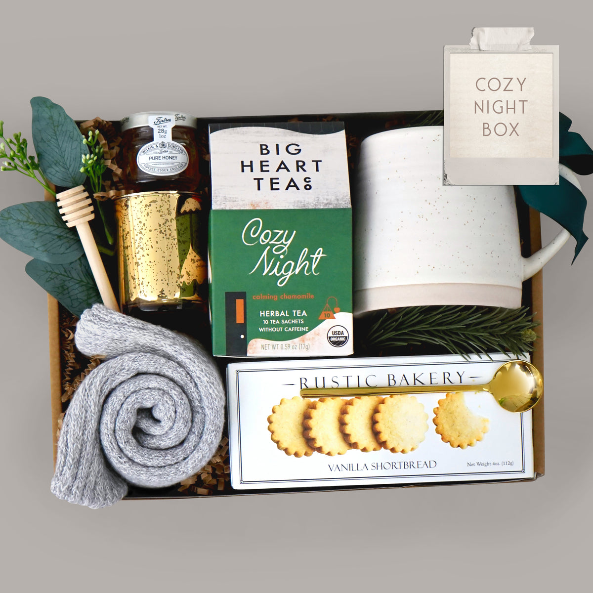 Gift basket with tea, cookies, and other items on a gray background