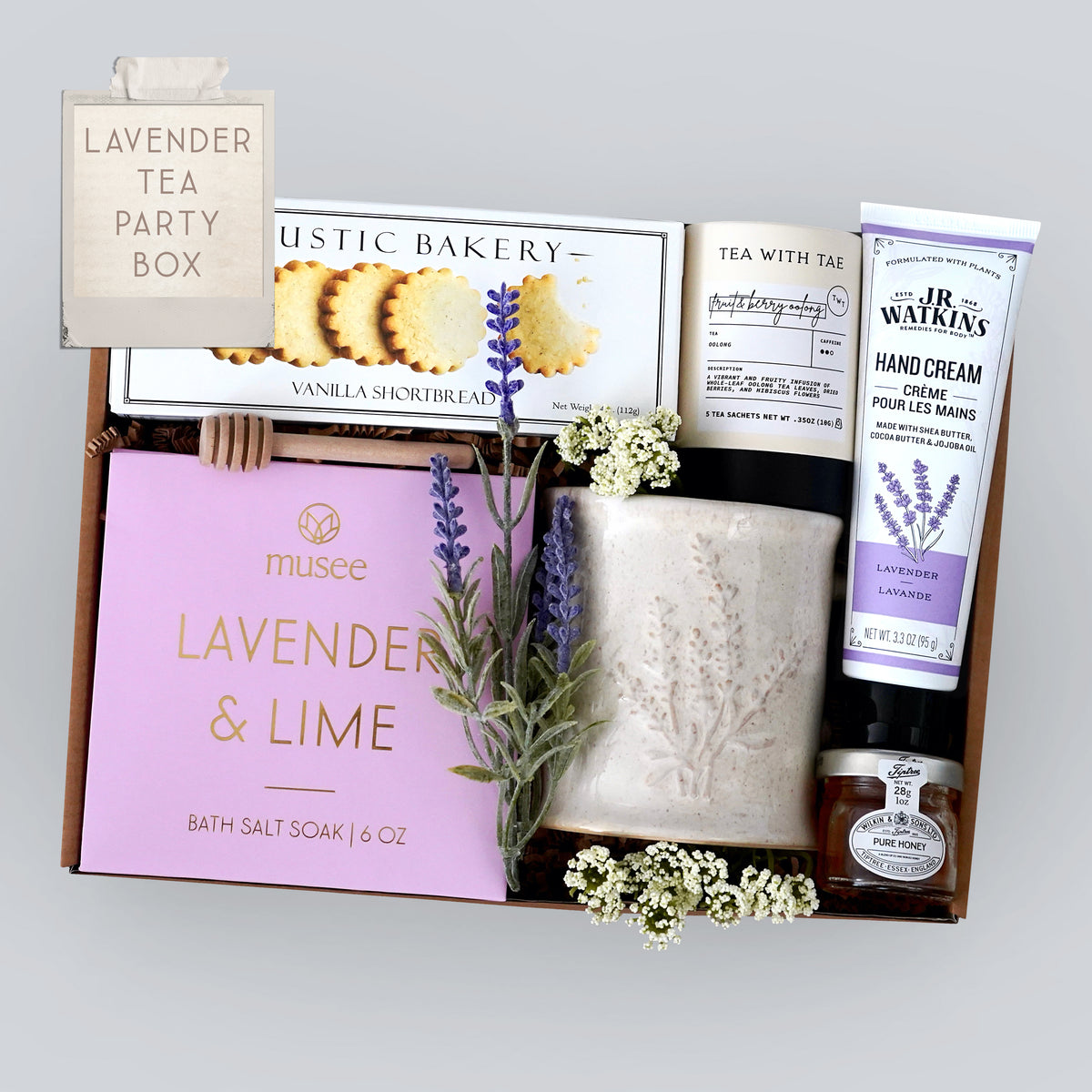 Wildflower Pop Gift box with lavender-themed products including a lavender mug, shortbread cookies, hand cream, tea, and mini honey on a gray background