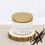 Wildflower Pop Candle labeled 'Warm Vanilla Cream' on a wooden coaster with vanilla beans beside it.
