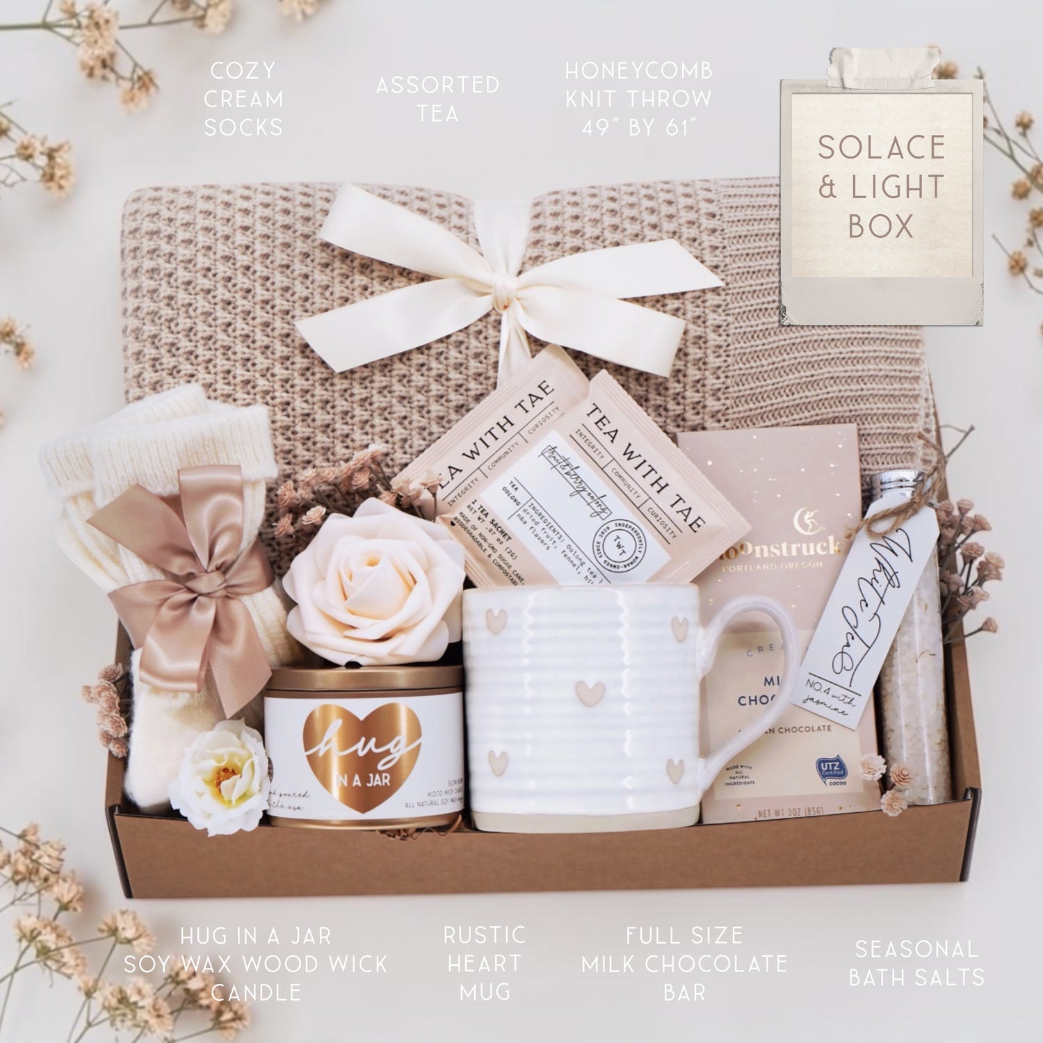 Wildflower Pop Solace and Light blanket gift box comes with honeycomb blanket, cream knit socks, hug in a jar soy wax candle, Wildflower Pop Hearts ceramic mug, 2 tea bags, Moonstruck milk chocolate bar, and floral bath salts