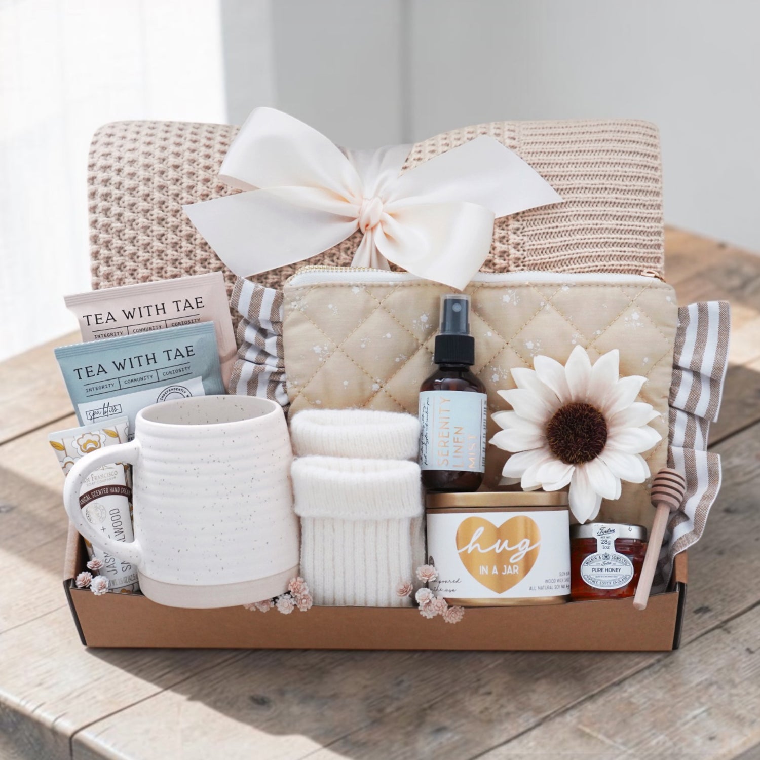 Sweet Honeybee luxury gift box featuring honeycomb knit blanket, candle, tea, mug, honey jar, socks, and self-care essentials