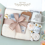 The best mama blanket box comes with a cream lace knit blanket tied in a nude ribbon, 2 tea with tea tea bags, gold demitasse spoon, heart coaster, full size Moonstruck milk chocolate bar, 4" box of matches, mama peony ceramic mug, best mama soy wax candle, cream knit socks, faux forever rose 
