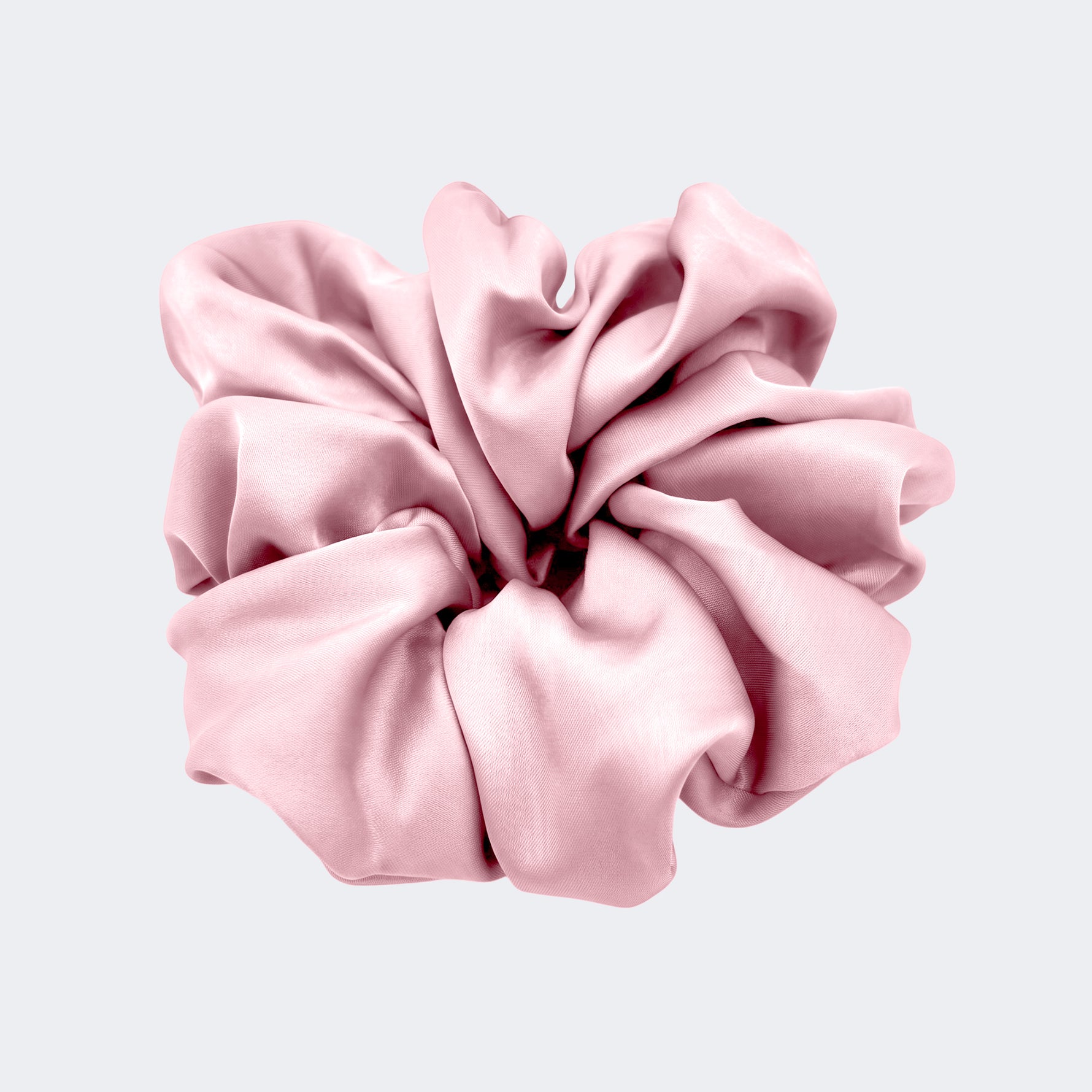A single jumbo satin hair scrunchie in Blushing pink centered on a light gray background.background.
