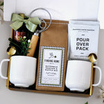Breakfast for Two Gift Box for Couples includes 2 ceramic white ribbed mugs, 2 gold spoons, 1 dough whisk, 1 1.7oz maple syrup, 2 single serve coffee packs, and one 24oz pancake and waffle mix