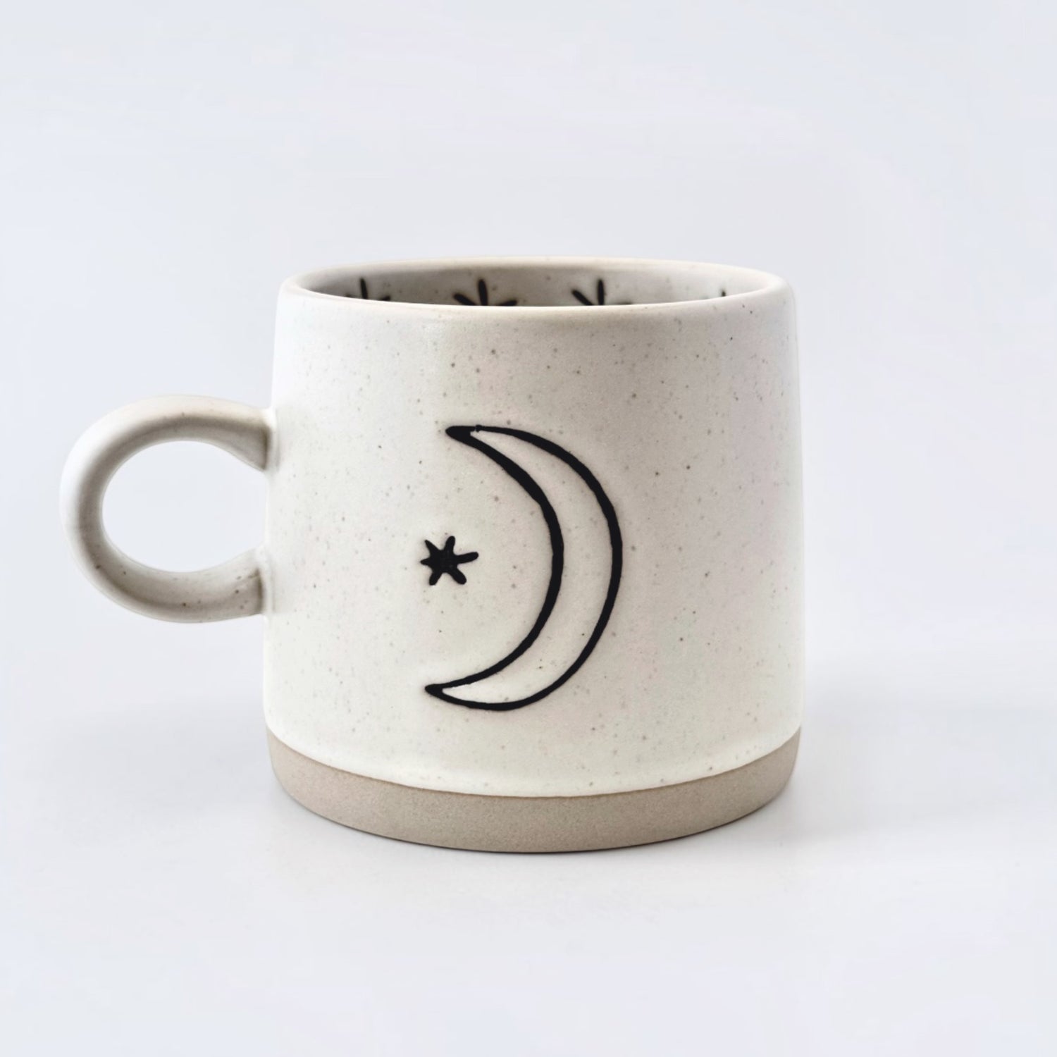 Ceramic mug with crescent moon and star design on a white background