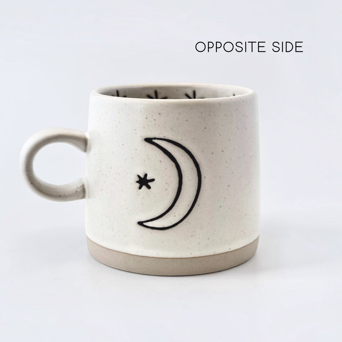 Ceramic mug with crescent moon and star design on a white background
