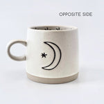 Ceramic mug with crescent moon and star design on a white background