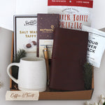 Coffee and Treats comes with a Wildflower Pop Beehive Stoneware Mug, Tan faux leather travelers notebook, Everton Toffee Pretzels, Backporch Coffee Roasters Pour Over Pack, Moonstruck Dark chocolate Espresso, pen, Sweets Chocolate Salt Water Taffy