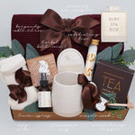 Wildflower Pop Ruby Spa Box with Burgundy blanket, bath salts, bath bomb, linen mist, cream socks, tea sampler, and mini honey and dipper. On light grey background 