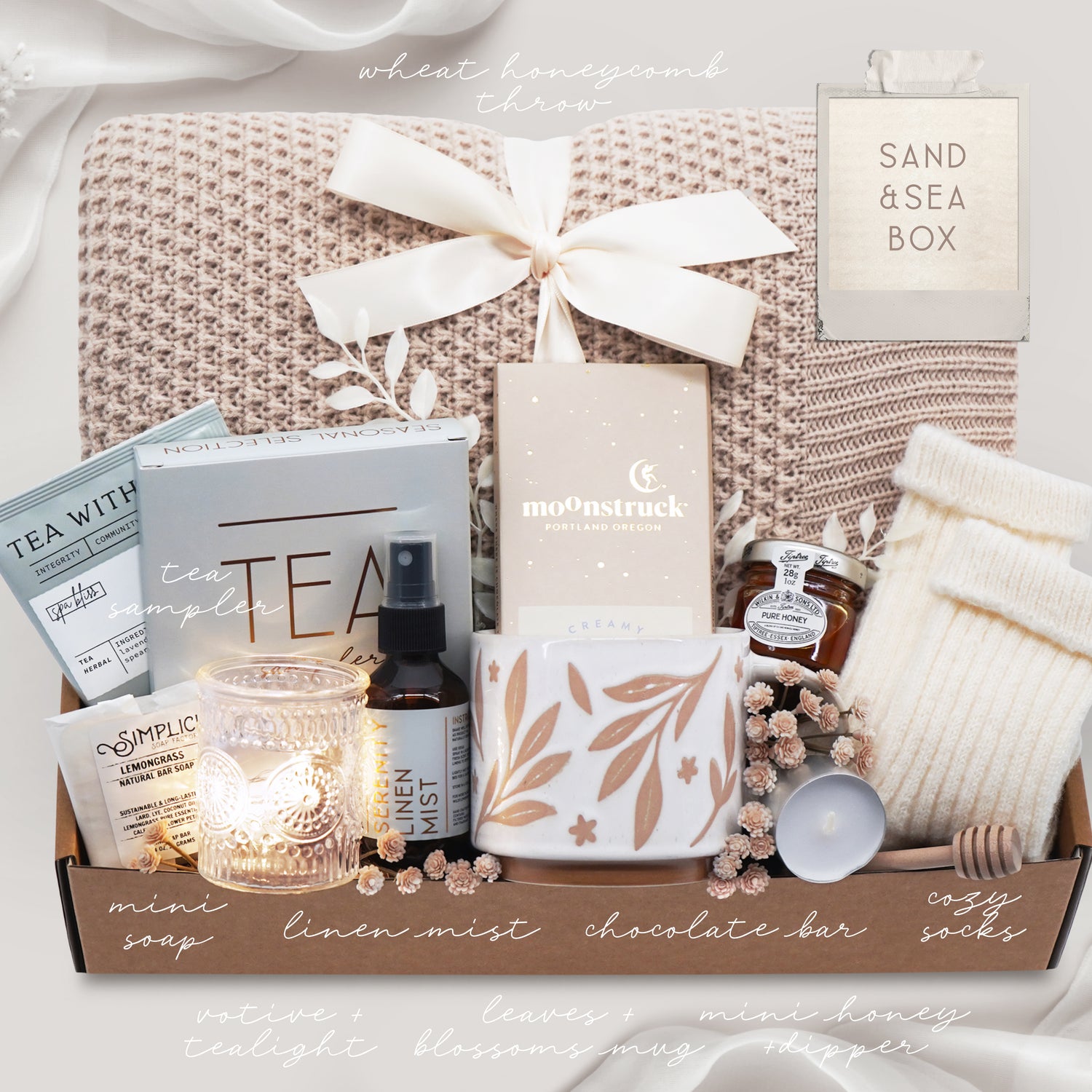 Neutral coastal inspired self care gift box with blanket, socks, candle and tea