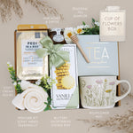 Gourmet gift set with tea, cookies, and other items on a neutral background