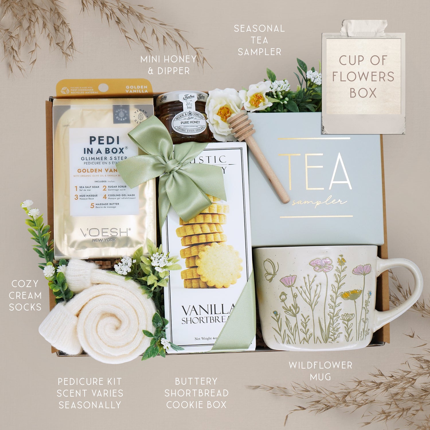 Gourmet gift set with tea, cookies, and other items on a neutral background