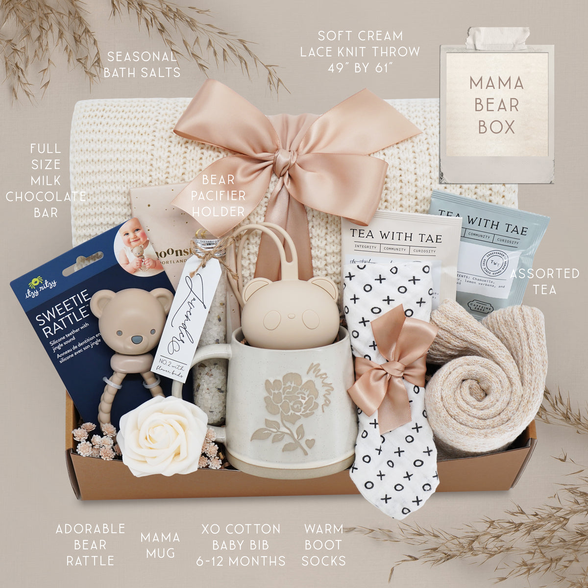 Mama Bear Box with baby items including a mug, rattle, and tea set on a neutral background.