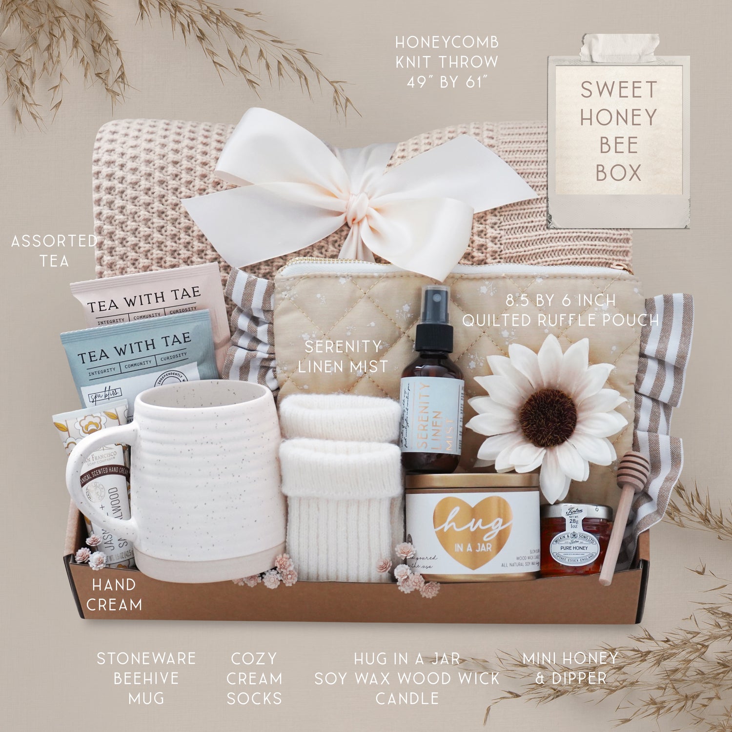 Cozy Mother’s Day gift set with soft wheat knit blanket, vanilla candle, tea, linen mist, and elegant self-care items arranged in a curated gift box