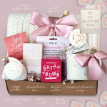 Valentine's Day gift box with various items on a pink background
