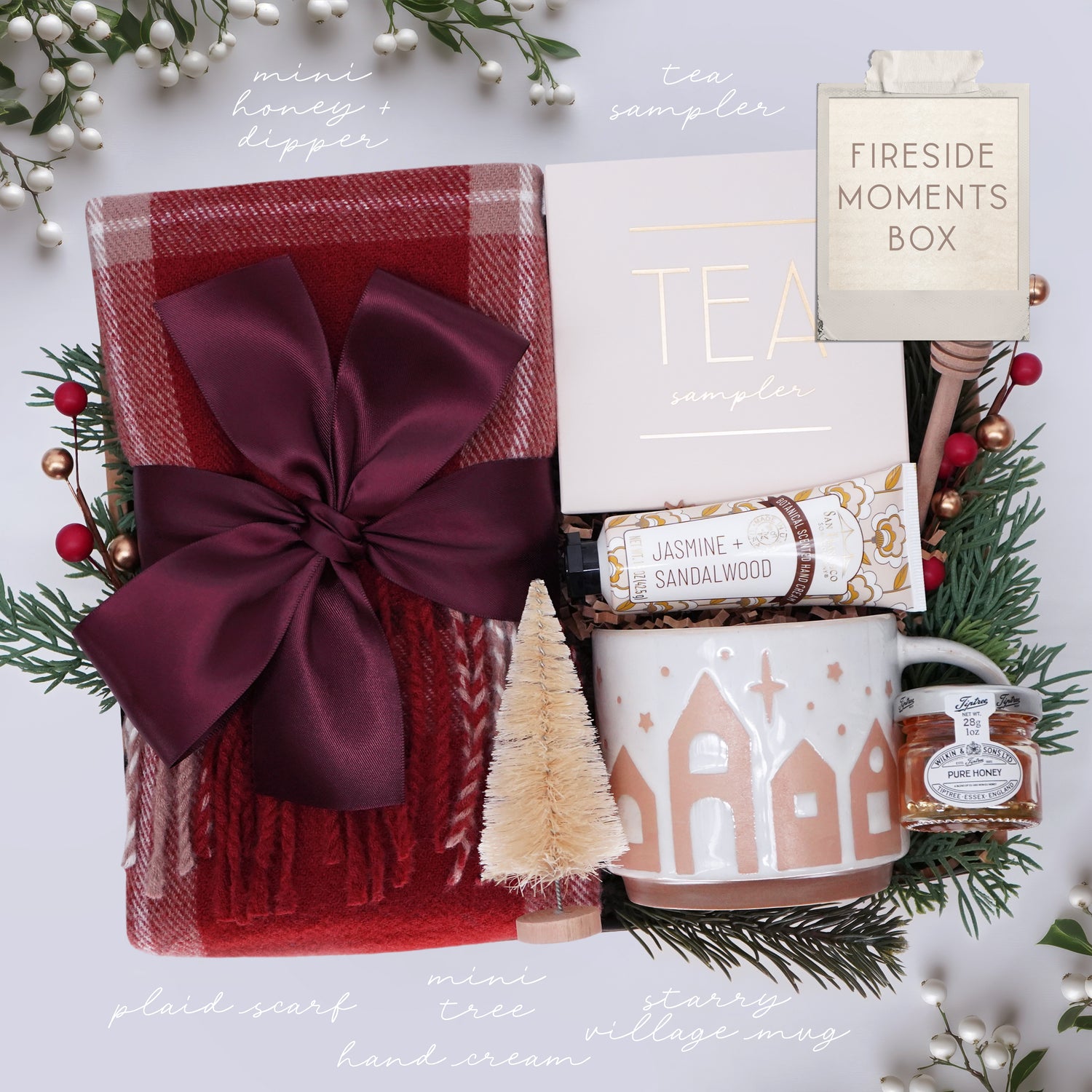 Fireside Moments Box with tea, mug, and other items on a white background with Christmas decorations.
