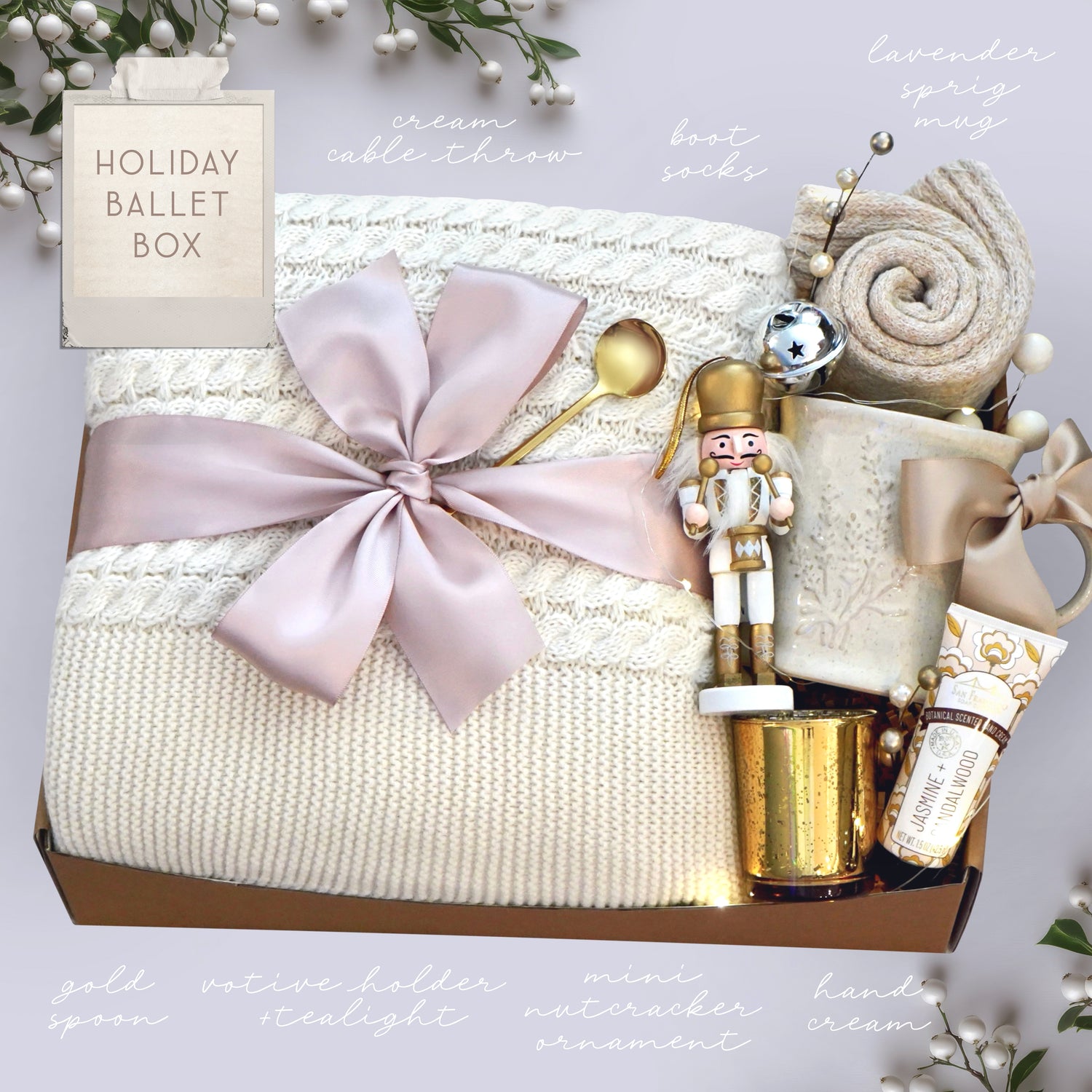 Wildflower Pop Holiday Ballet Blanket box with cream cable knit blanket, nutcracker ornament, lavender ceramic mug, hand cream gold votive and cozy boot socks on grey holiday background