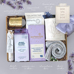 Mini spa day box with various items including tea, chocolate, and socks on a gray background.