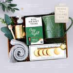 Wildflower Pop Gift set with a green mug, tea packaging, and cookies in a decorative box, grey cozy socks, gold votive, and mini honey and dipper on grey background