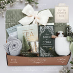 Gift box with tea, shower steamer, and other items on a white background