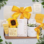 Wildflower Pop Sunny Days Ahead blanket gift box with a cream lace knit blanket, Wildflower Pop daisy ceramic mug, scallop trinket dish, moonstruck milk chocolate and toffee bar, little drop of sunshine bath bomb, faux sunflower, deep steep lotion, and cream knit socks