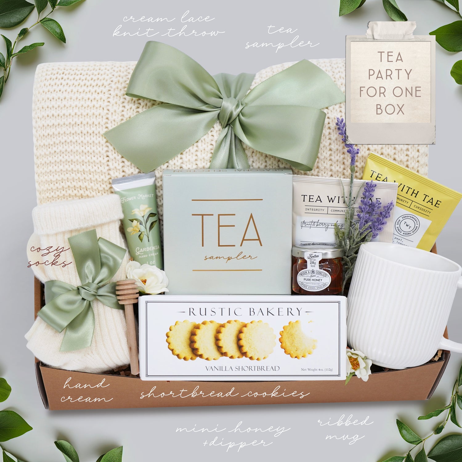 Gift box with tea, cookies, and other items on a light background