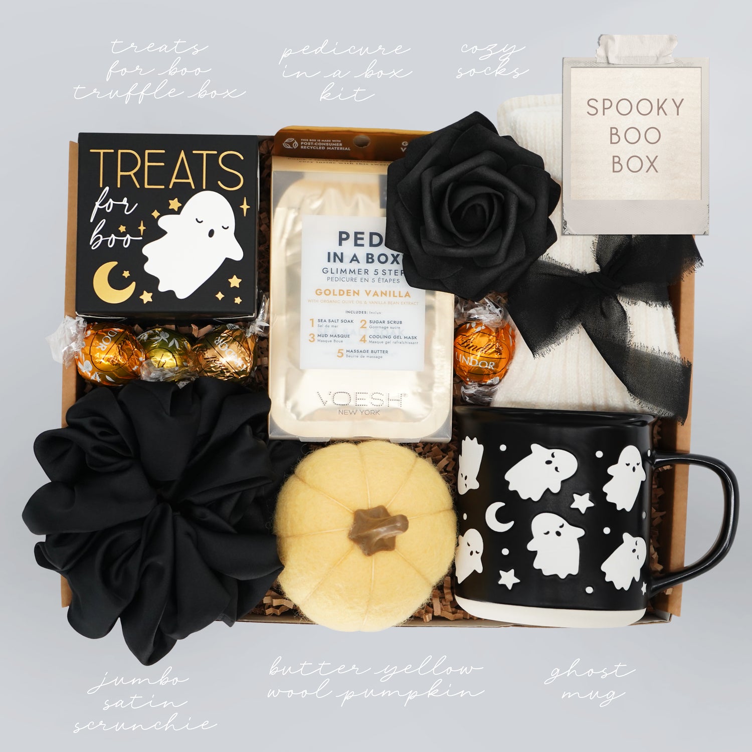 Spooky themed gift box with Halloween-themed items on a light gray background
