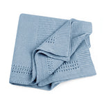 A folded cornflower blue-colored lace knit blanket with textured patterns, shown on a solid white background.