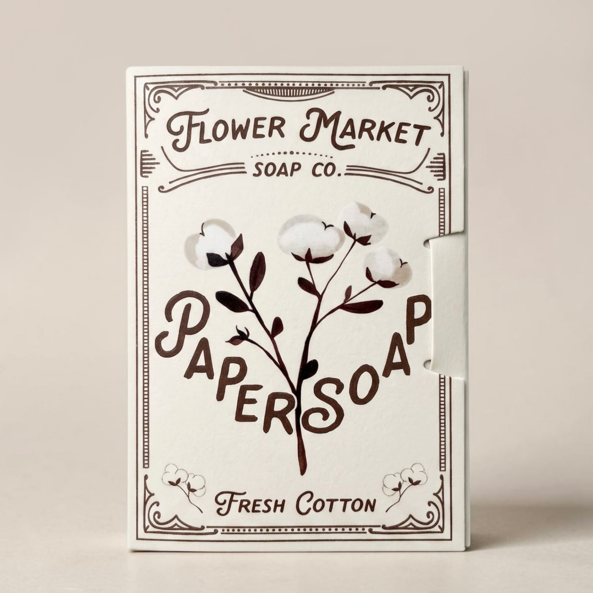 Flower Market Soap Co. Paper Soap in Fresh Cotton scent. Cream-colored packaging with dark brown typography and cotton illustrations, styled on a cream background.
