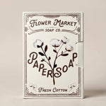 Flower Market Soap Co. Paper Soap in Fresh Cotton scent. Cream-colored packaging with dark brown typography and cotton illustrations, styled on a cream background.