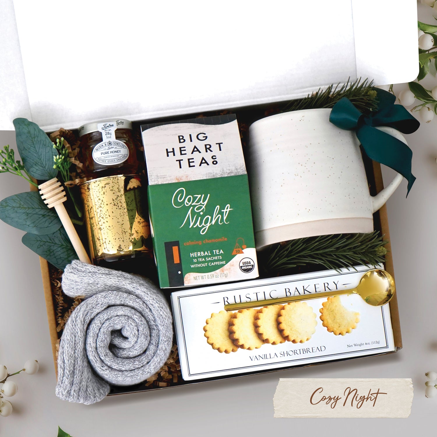 Cozy Night Gift Box comes with beehive ceramic mug, rustic bakery vanilla shortbread cookies, cozy night 10 count tea bags, mini honey and dipper, votive and tea light, and cozy socks