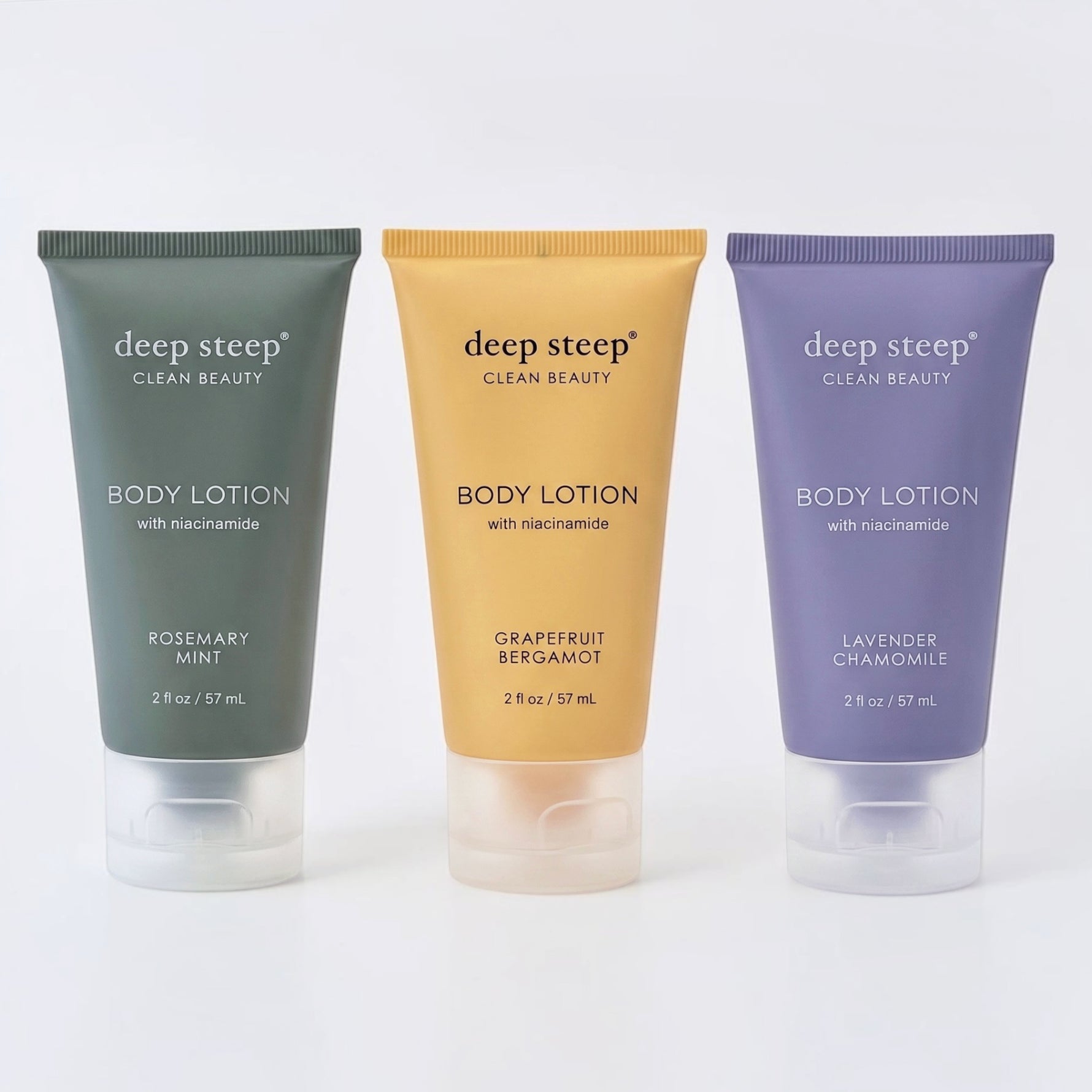 Three squeeze tubes of deep steep Clean Beauty body lotion lined up on a white background. From left to right Rosemary Mint scent, Grapefruit Bergamot scent, and Lavender Chamomile scent.