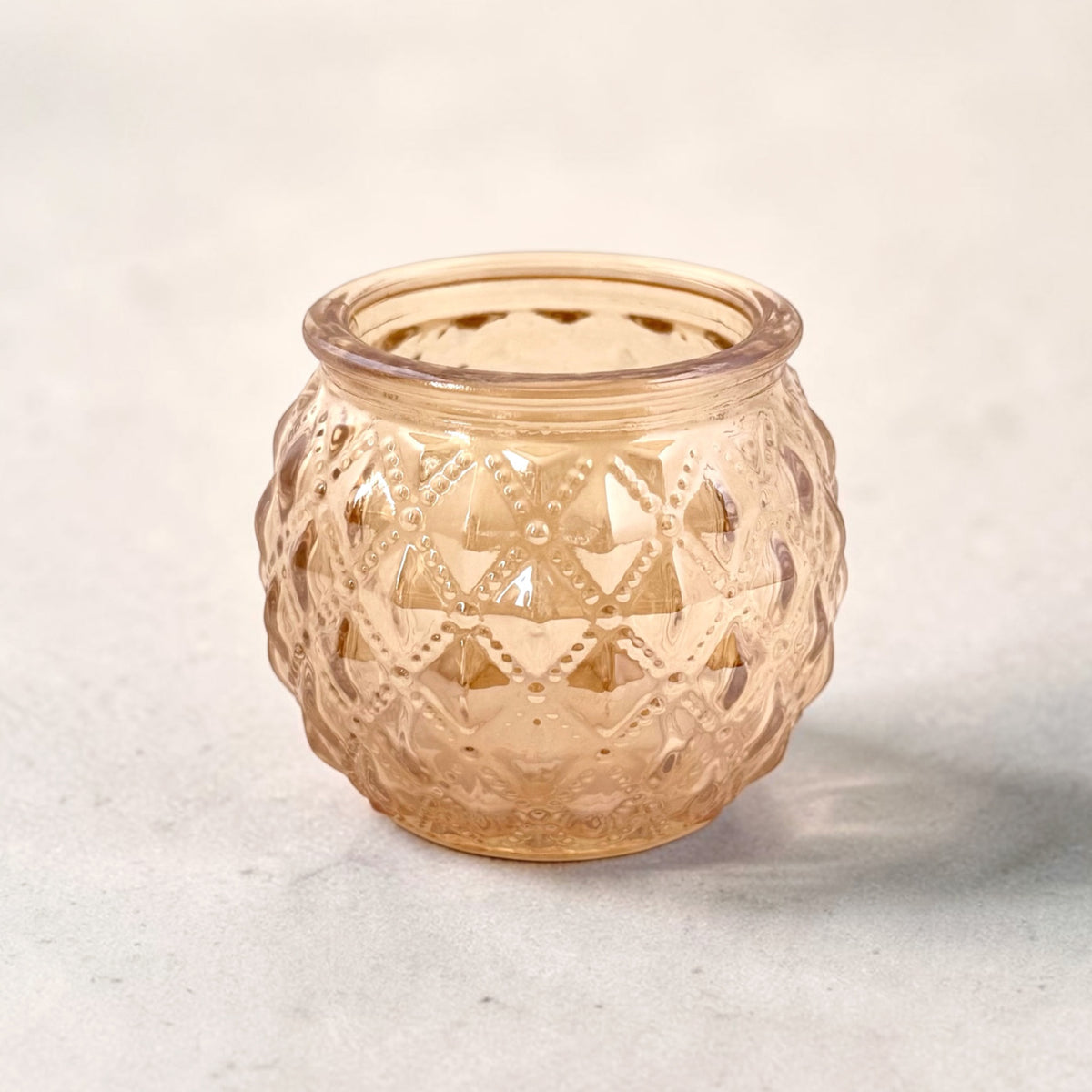 Rose Gold Votive on a grey surface