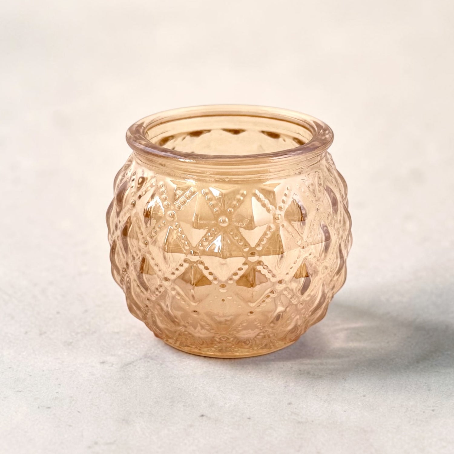 Rose Gold Votive on a grey surface