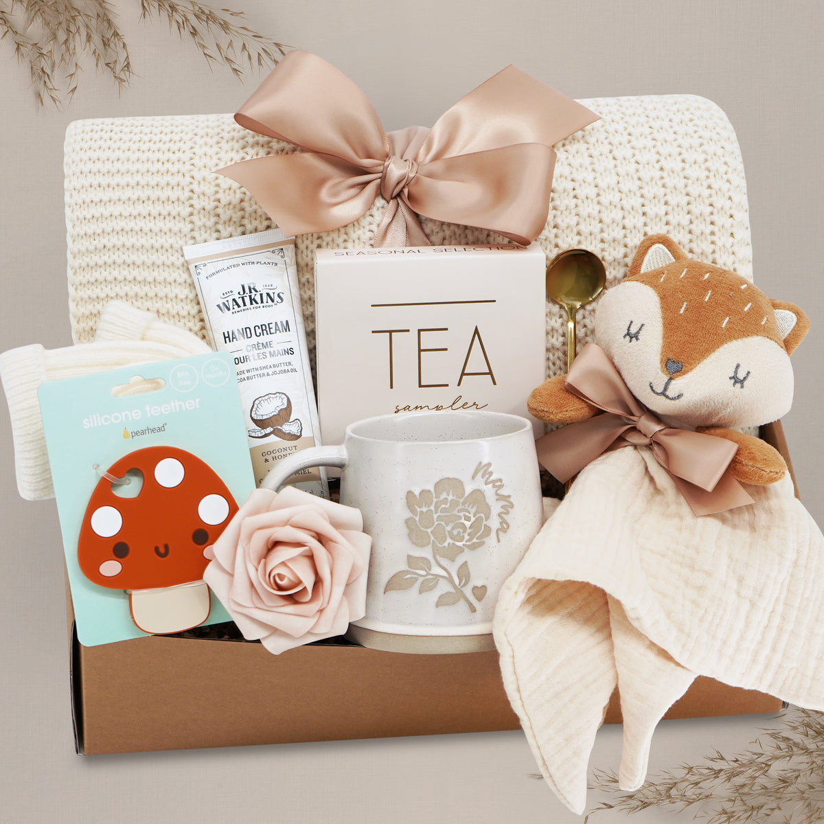 Wildflower Pop Forest Friends New Baby and New Mama Blanket Gift Box comes with a cream lace knit blanket tied with a nude bow, JR Watkins lotion, Pearhead Mushroom silicone teether, faux rose, Wildflower Pop ceramic mama mug, Tea Sampler, Fox movie and gold demiatsse spoon