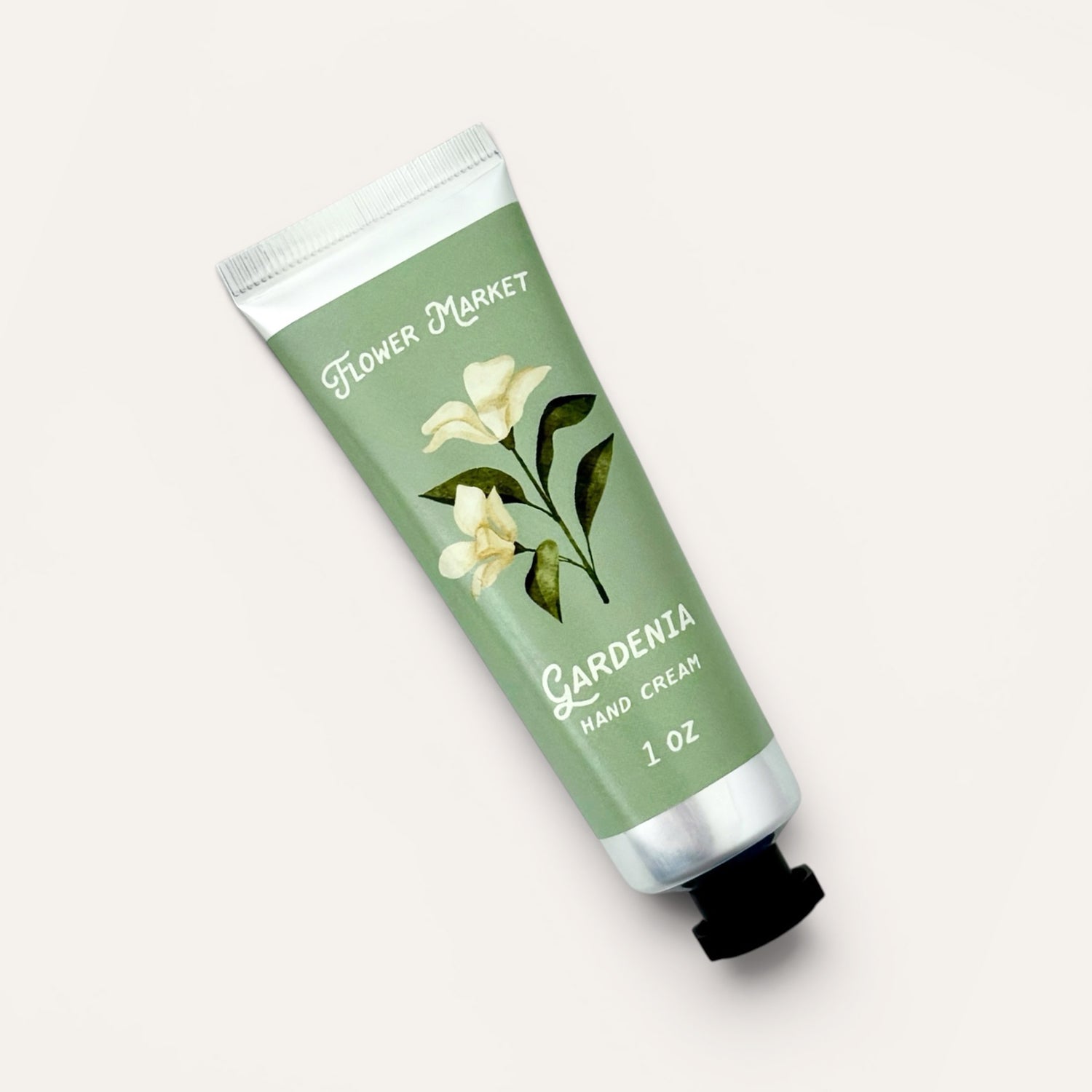 Hand cream tube labeled 'Gardenia' from 'Flower Market' on a light background