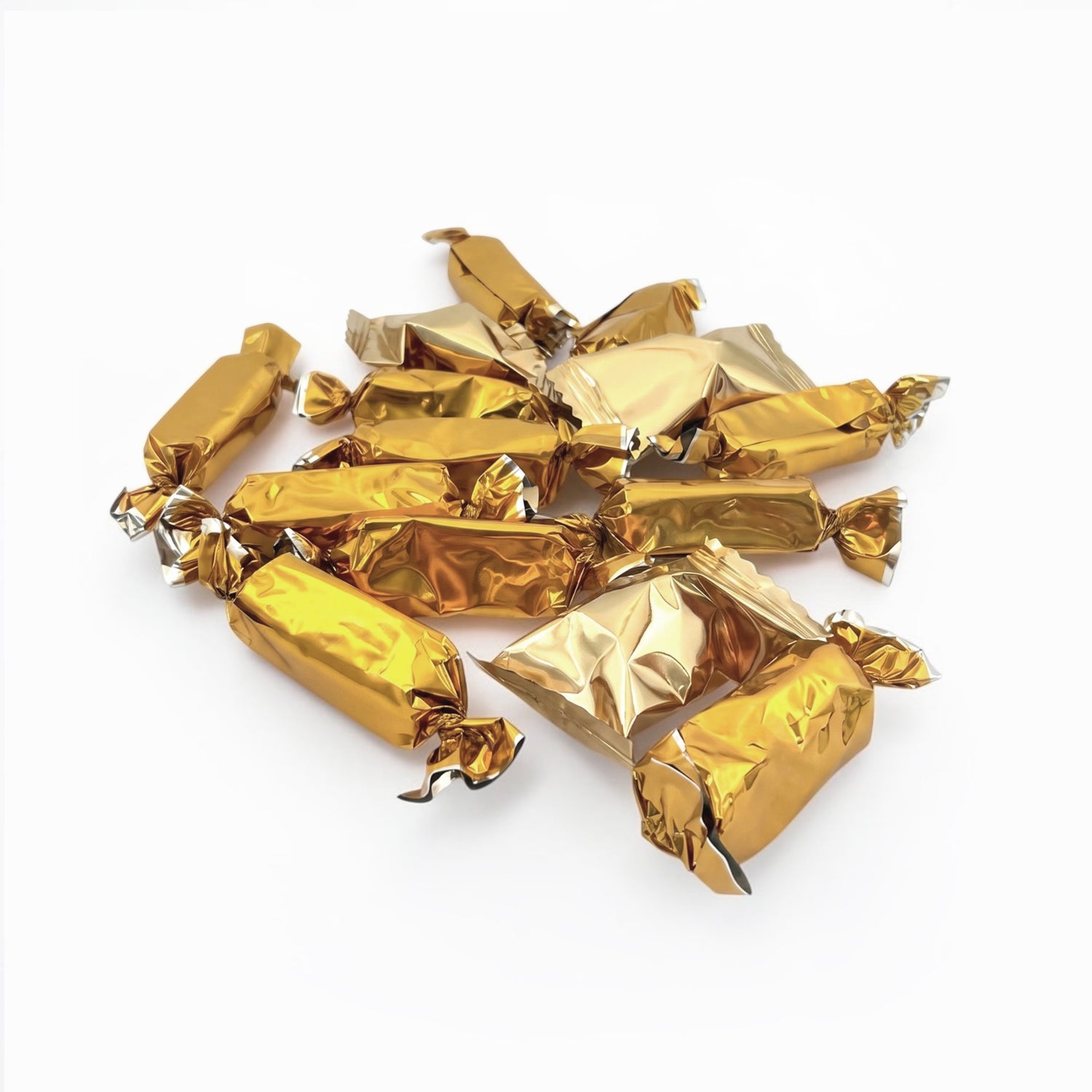 A pile of wrapped candies or chocolates individually wrapped in shiny metallic gold foil, arranged on a plain white background.